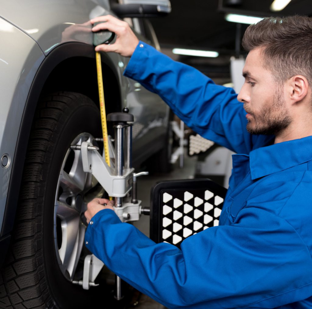 Mechanic measuring a vehicles wheels - Wheel Alignment Rotherham